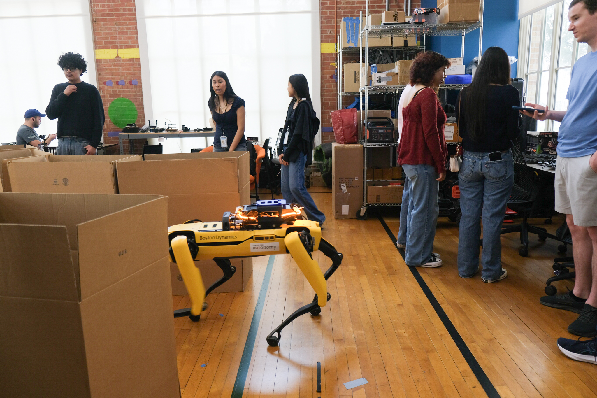 A quadruped robot navigates an obstacle course during the hands-on robot demos, where students take turns guiding robots with remote controls. Credit: Tai Cerulli/Oden Institute
